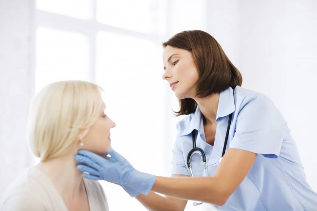 an ent examines a patient's neck
